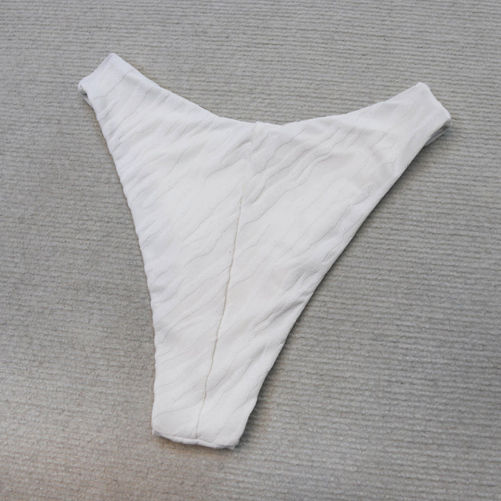 חלק תחתון בגד ים לבן על רקע אפור, בסגנון Lika Swimwear.